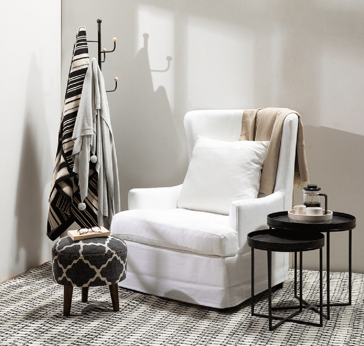 A classic slipcover armchair in linen with foot stool and side table make a perfect reading corner