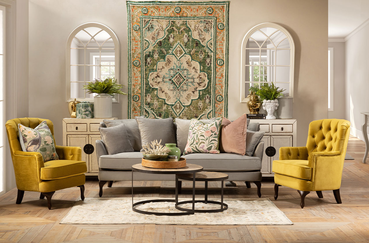 Mustard yellow velvet armchairs with handwoven rugs and plush grey velvet sofa