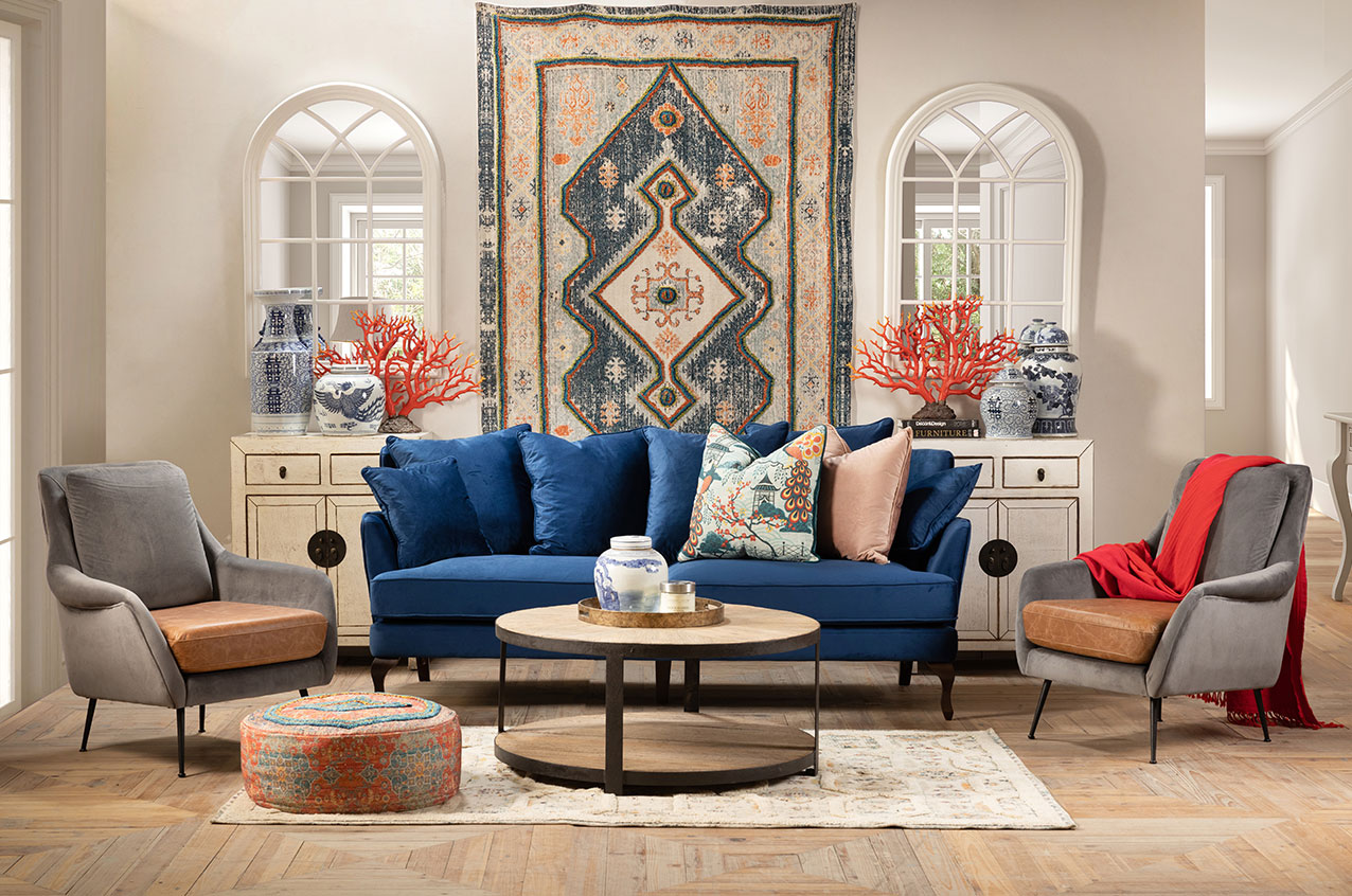 Blue velvet sofa with handwoven rugs and round metal coffee table
