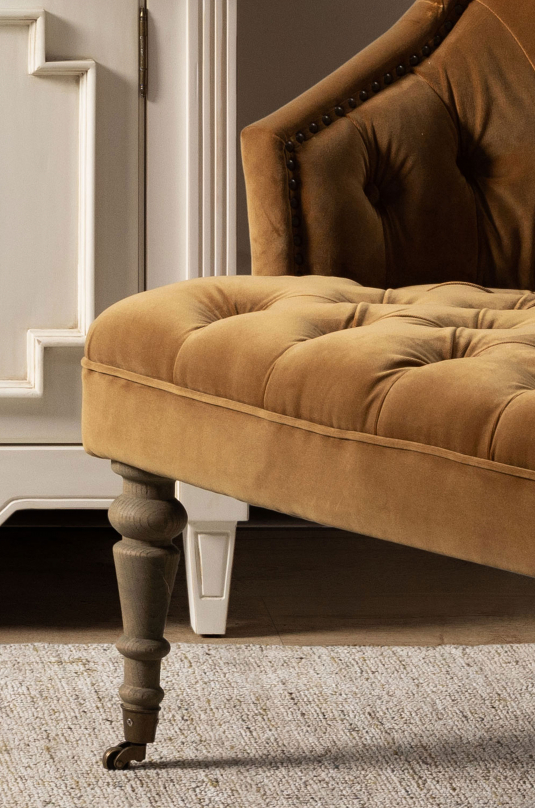 Deco chair upholstered in gold velour with deep buttoned detail, oak legs and castors Château Collection