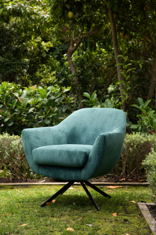 Swivel tub chair with black metal legs upholstered in a green fabric. 