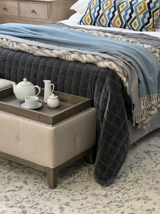 Cleopatra Bed end in cream linen with tufted detail and wooden legs with convertible trays