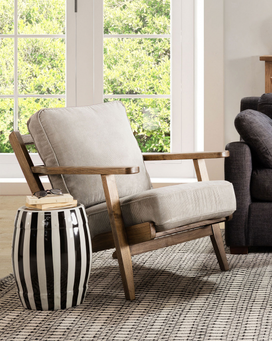 Wooden frame lounge chair with loose cushions upholstered in a grey fabric. 