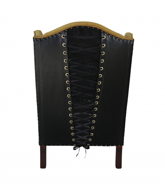 wingback chair in gold velvet and leather corset detail at the back