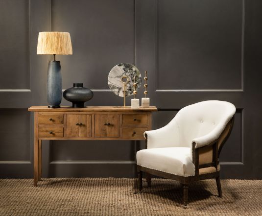 Deconstructed occasional chair with castors, upholstered in ivory fabric.
