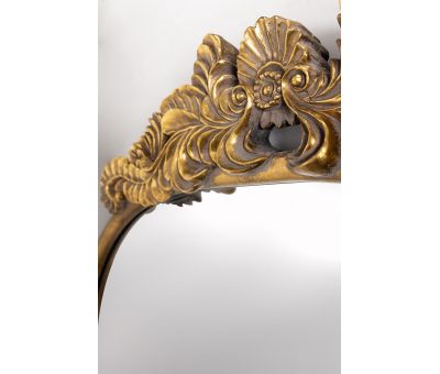 Gold framed mirror with ornate top