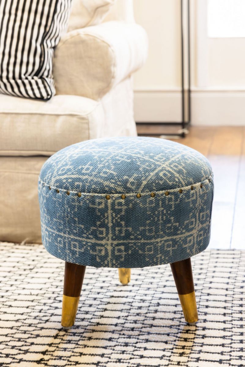 blue upholstered stool with 3 legs