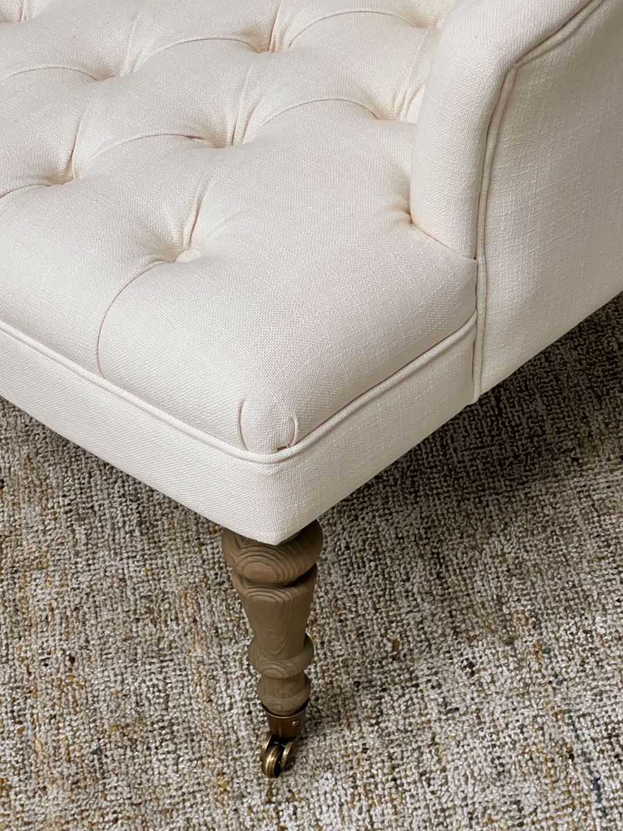 cream upholstered deco chair with deep buttoned detail, oak legs and castors, Château Collection 