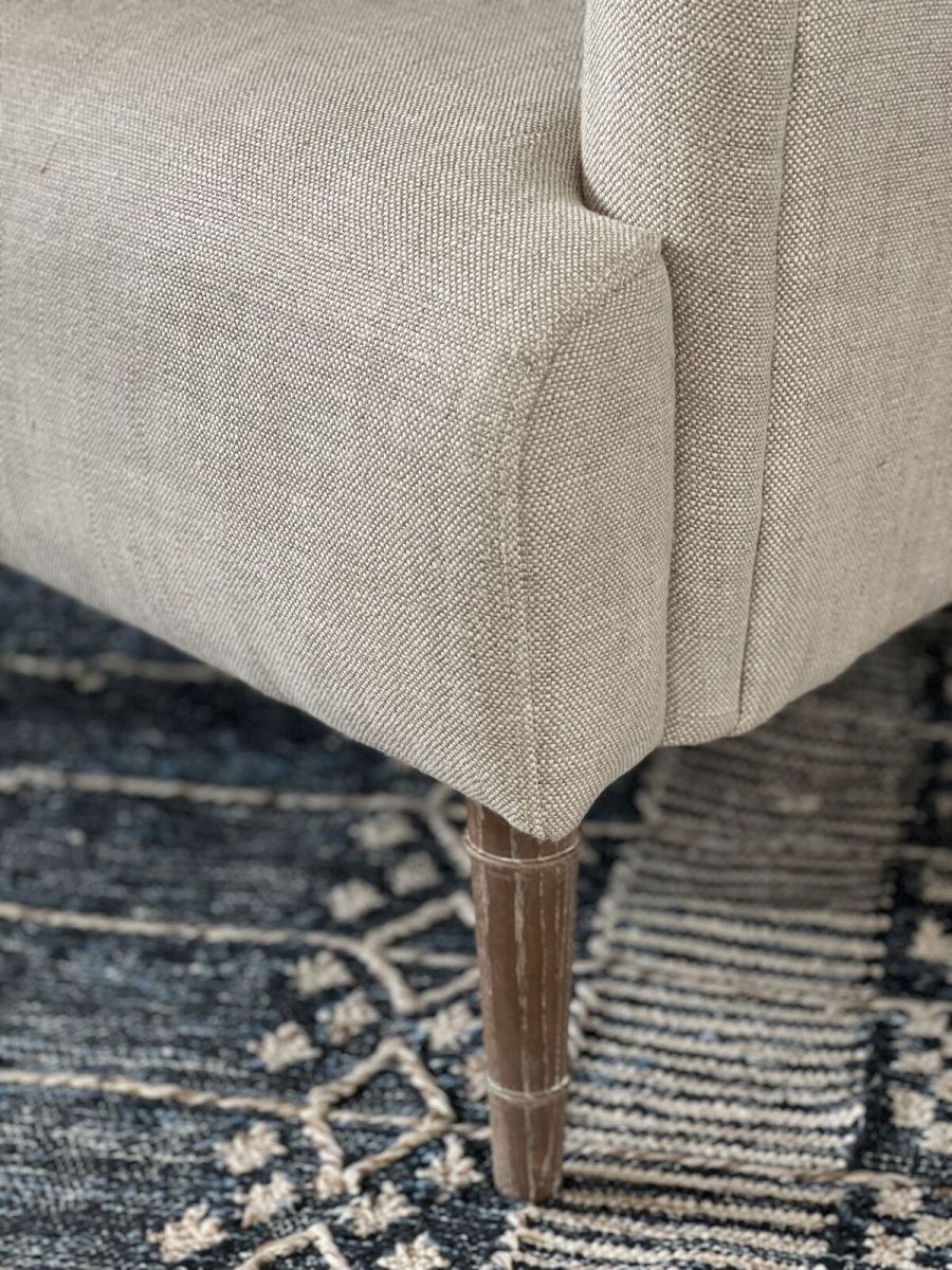 Upholstered armchair with wooden legs linen