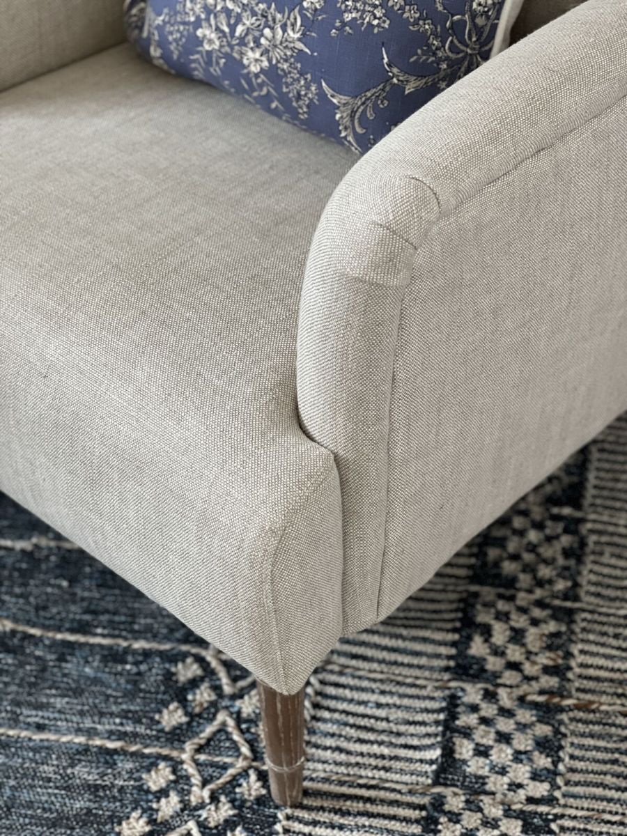 Upholstered armchair with wooden legs linen