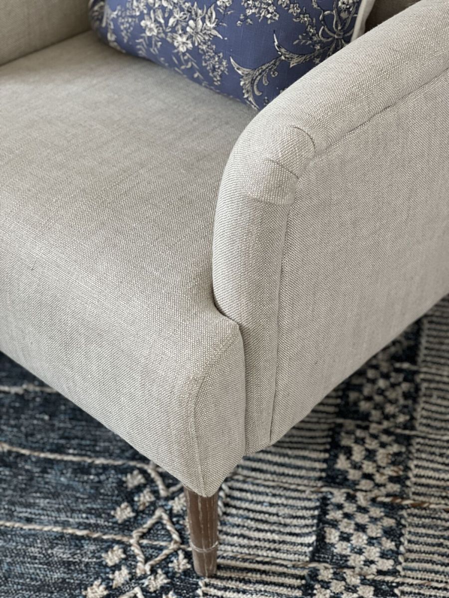 Upholstered armchair with wooden legs linen