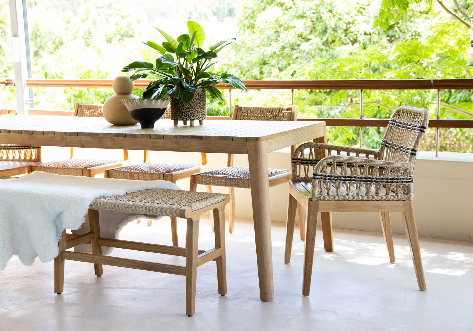 Outdoor dining armchair with teak frame and synthetic rope weave
