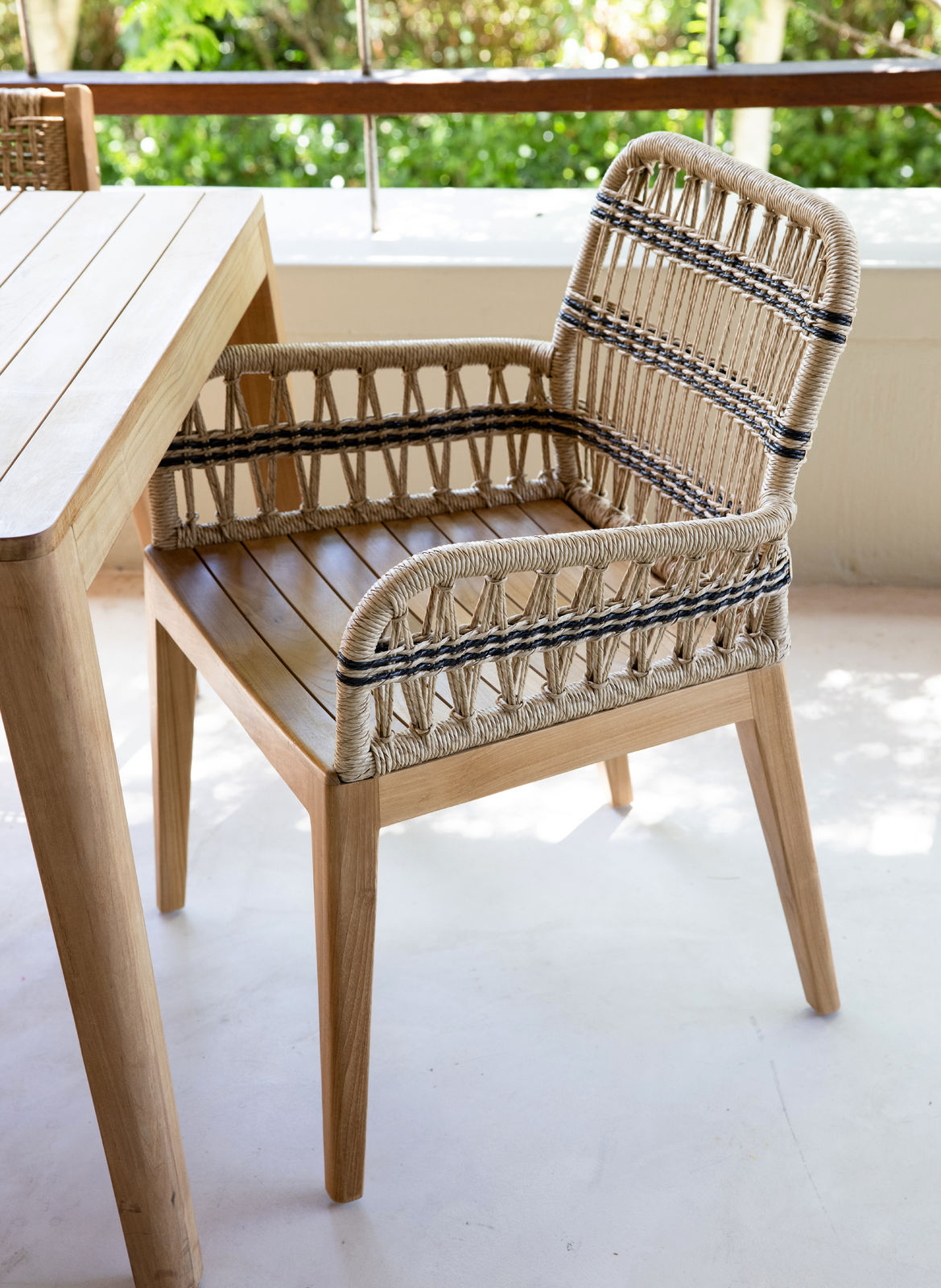 Outdoor dining armchair with teak frame and synthetic rope weave